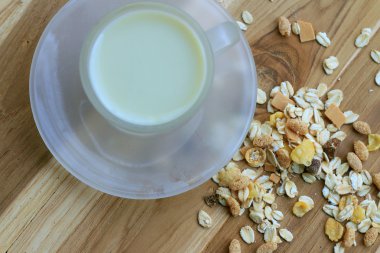 Yulaf gevreği ve ahşap arka plan üzerinde süt.