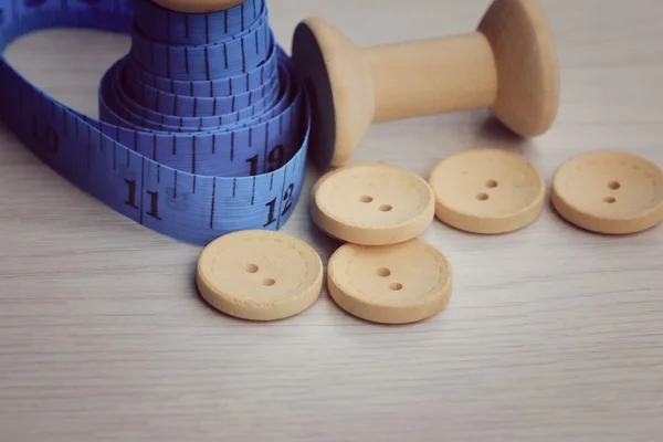 Measure tape and bobbin and wood buttons. — Stock Photo, Image