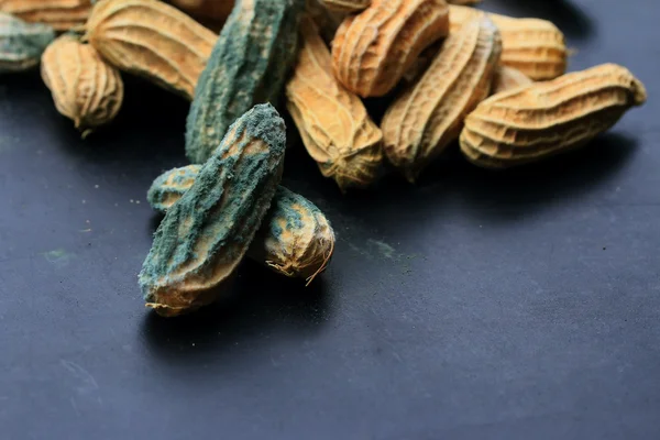 Heap of moldy peanuts on a black background — Stock Photo, Image