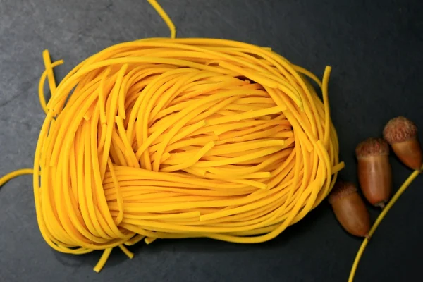 Yellow noodles drying on black background — Stock Photo, Image