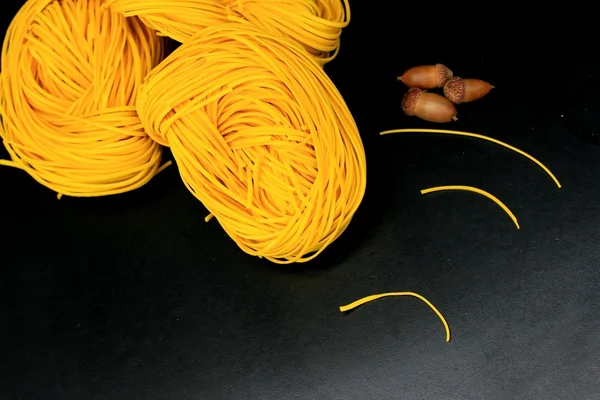 Yellow noodles drying on black background — Stock Photo, Image