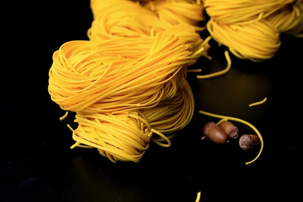 Yellow noodles drying on black background — Stock Photo, Image