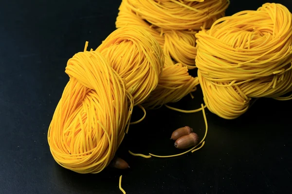 Yellow noodles drying on black background — Stock Photo, Image