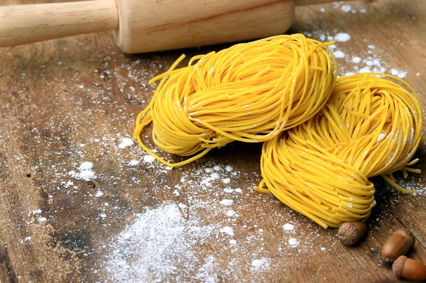 Yellow noodles drying on wood background — Stock Photo, Image