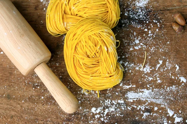 Fideos amarillos secado sobre fondo de madera — Foto de Stock