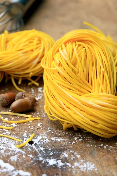 Fideos amarillos secado sobre fondo de madera — Foto de Stock