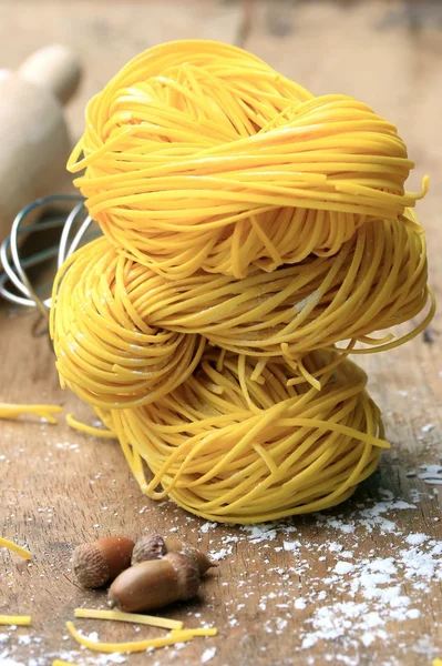 Fideos amarillos secado sobre fondo de madera — Foto de Stock