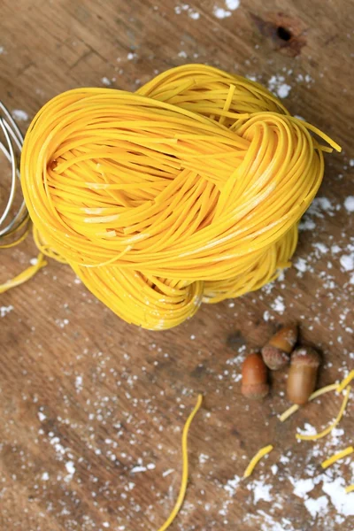 Fideos amarillos secado sobre fondo de madera — Foto de Stock