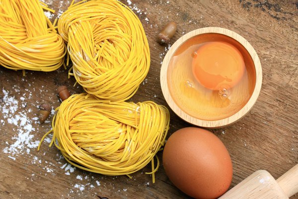 yellow noodles drying on wood background