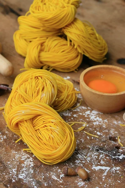 Fideos amarillos secado sobre fondo de madera — Foto de Stock