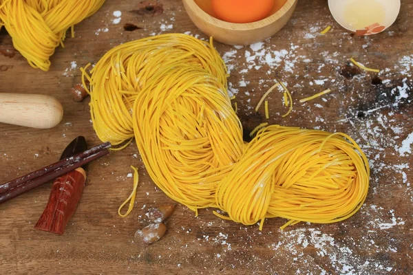 Fideos amarillos secado sobre fondo de madera — Foto de Stock