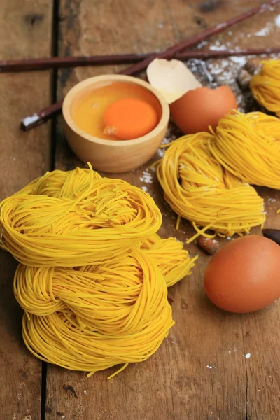 Fideos amarillos secado sobre fondo de madera — Foto de Stock