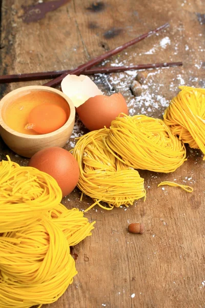 Fideos amarillos secado sobre fondo de madera — Foto de Stock