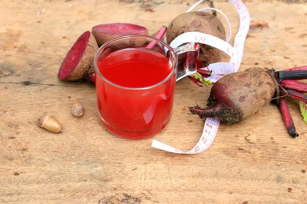 Jugo de remolacha de verduras frescas y una cinta métrica — Foto de Stock