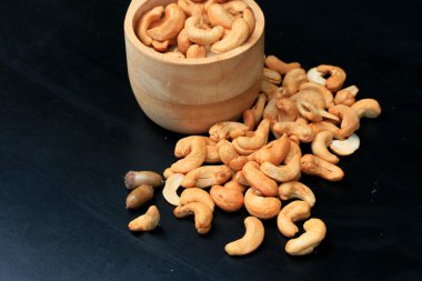 yığın kaju fıstığı ve siyah arka plan üzerine tuz