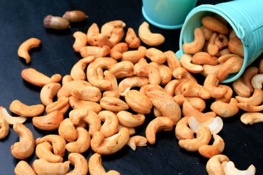 yığın kaju fıstığı ve siyah arka plan üzerine tuz