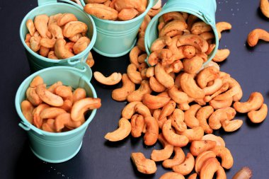 yığın kaju fıstığı ve siyah arka plan üzerine tuz