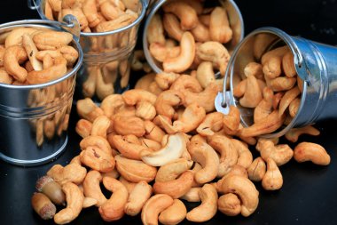 yığın kaju fıstığı ve siyah arka plan üzerine tuz