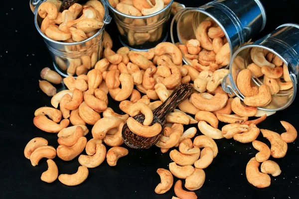 heap cashew nuts and salt on black background