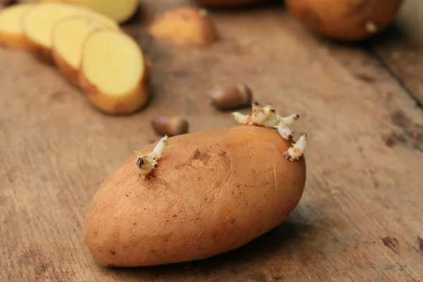 Kartoffelkeime auf einem hölzernen Jahrgang — Stockfoto