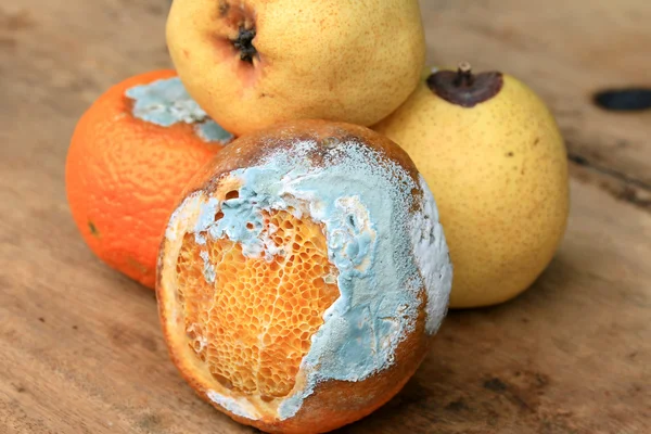 Pera podrida y fruta naranja en madera vintage — Foto de Stock