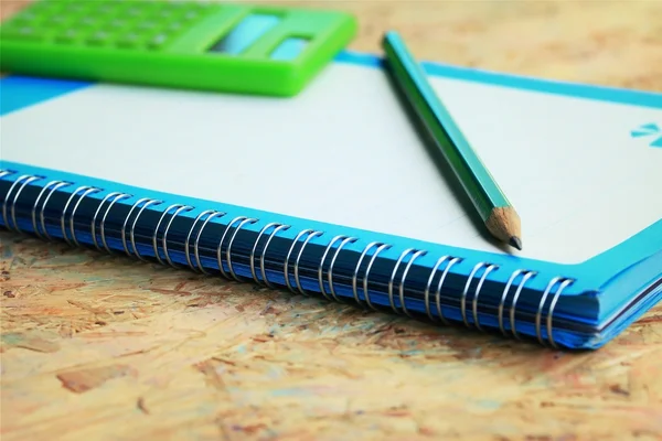 Mix book and calculator, stapler, tape, paper punch, pencil — Stock Photo, Image