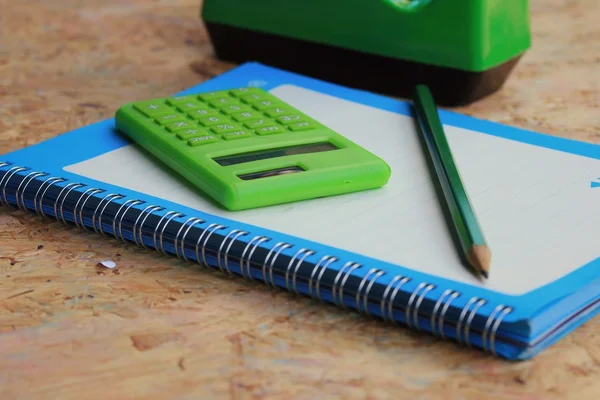 Mezclar libro y calculadora, grapadora, cinta adhesiva, ponche de papel, lápiz — Foto de Stock