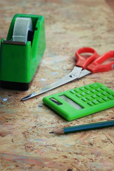 Mix book and calculator, stapler, tape, paper punch, pencil — Stock Photo, Image