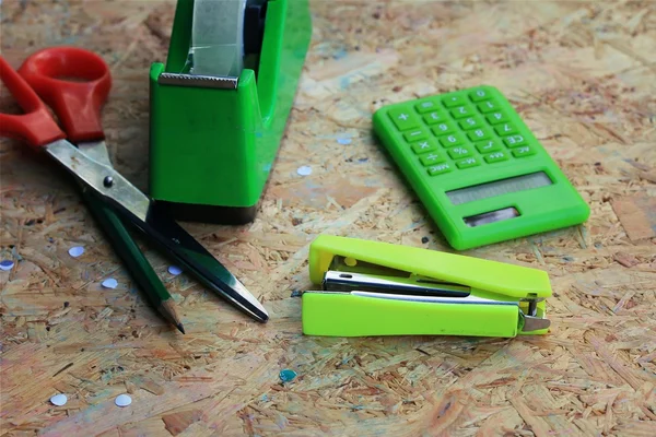 Meng boek en rekenmachine, nietmachine, tape, papier punch, potlood — Stockfoto