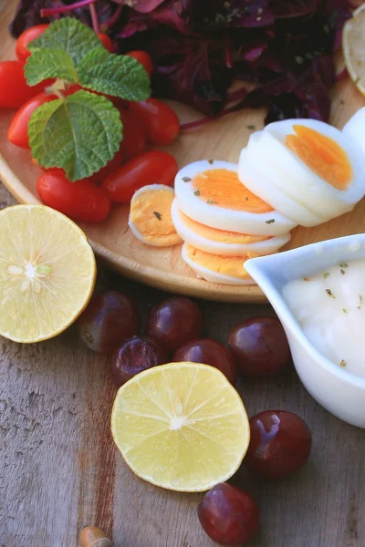 Verse rode spinazie salade en room op houten tafel — Stockfoto