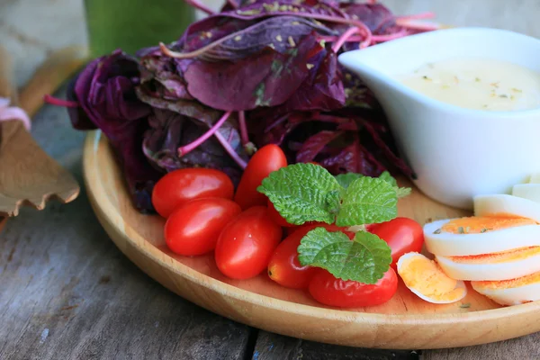 Fresh red spinach salad and cream on wooden table — Stock Photo, Image