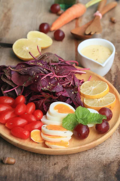 Verse rode spinazie salade en room op houten tafel — Stockfoto