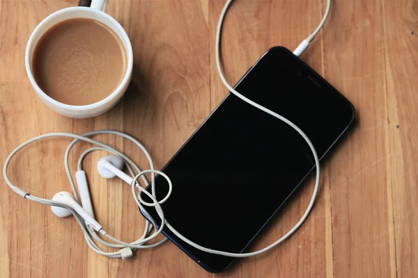 Warme koffie met slimme telefoon — Stockfoto