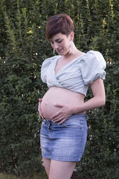 Jonge Zwangere Vrouw Een Groene Achtergrond Moederschap — Stockfoto