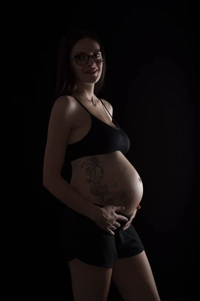 Беременная Женщина Нижнем Белье Держит Живот Стоя Черном Фоне — стоковое фото