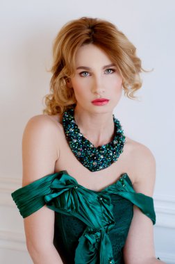 Yeşil restorasyon gece elbisesi ve neckla düzgün sarışın kadın