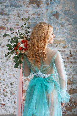 Charming young blond woman holding fresh flowers