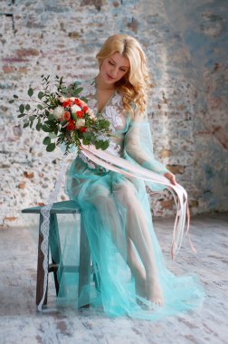 Charming young blond woman holding fresh flowers