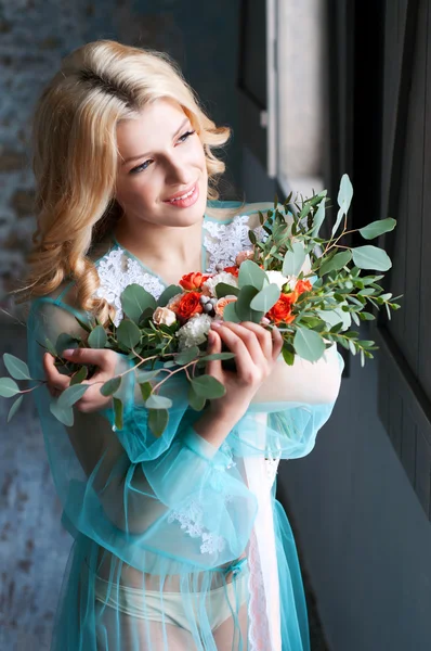 Encantadora jovem loira segurando flores frescas — Fotografia de Stock