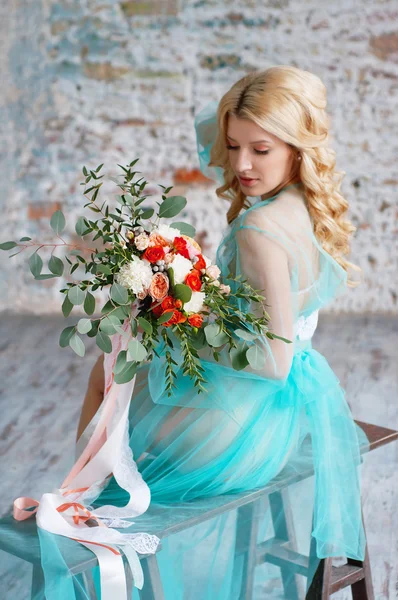 Charming young blond woman holding fresh flowers — Stockfoto