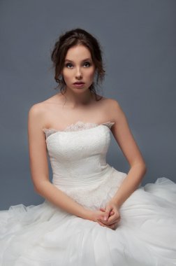 Bulutu içinde oturan Kahverengi kıvırcık saçlı sevimli genç gelin