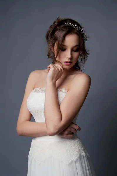 Entzückende junge Braut mit braunem lockigem Haar und Perlenkopf — Stockfoto