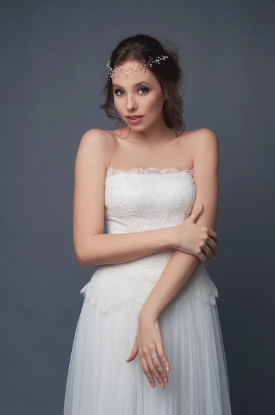 Timido sposa carina in abito da sposa bianco e copricapo in rilievo — Foto Stock