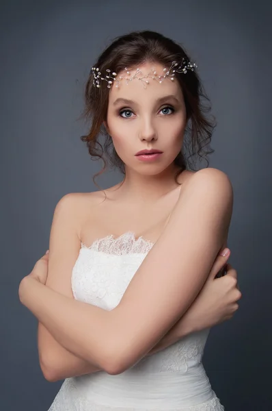 Timido sposa carina in abito da sposa bianco e copricapo in rilievo — Foto Stock