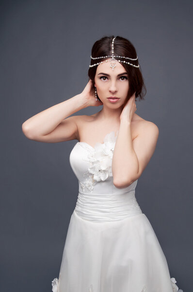 Brunette bride wearing tikka headpiece and white wedding dress