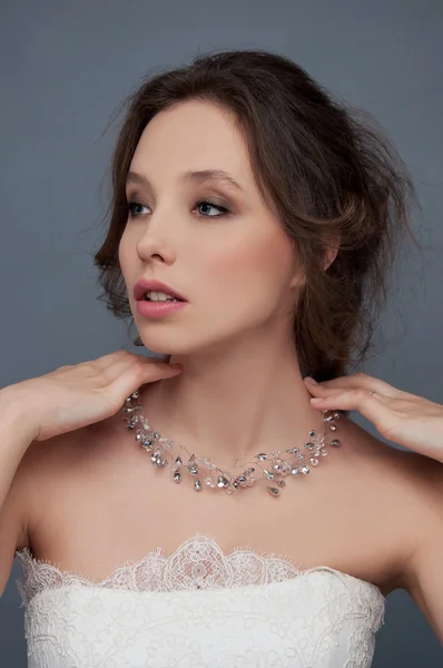 Adorable jeune mariée aux cheveux bouclés bruns assis dans un nuage de — Photo