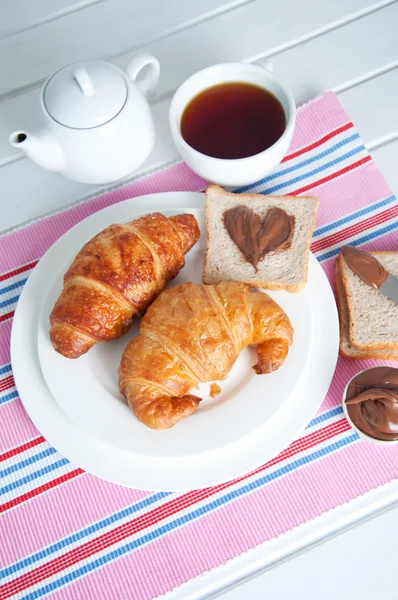 Desayuno del domingo. Croissants con té y mantequilla de maní . — Foto de Stock