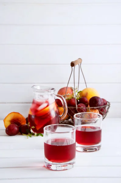 Iced fruit compote with peaches and plums. Cold summer drink. — Stock Photo, Image