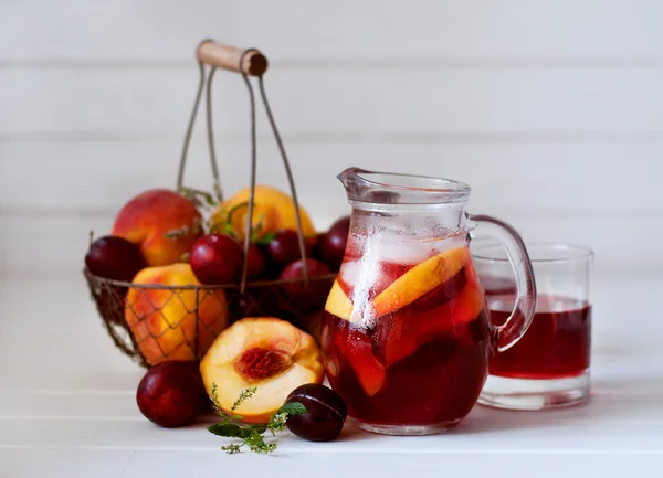 Iced fruit compote with peaches and plums. Cold summer drink. — Stock Photo, Image