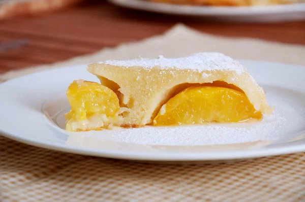 Pfirsich-Karamell-Torte mit Zuckerpulver bestreut lizenzfreie Stockbilder